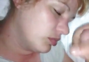 The sleeping lady is feeling his soft penis in front of her face